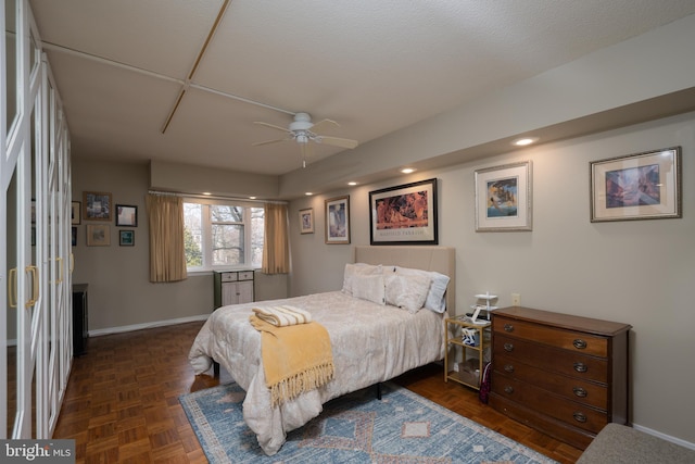 bedroom with dark parquet floors and ceiling fan