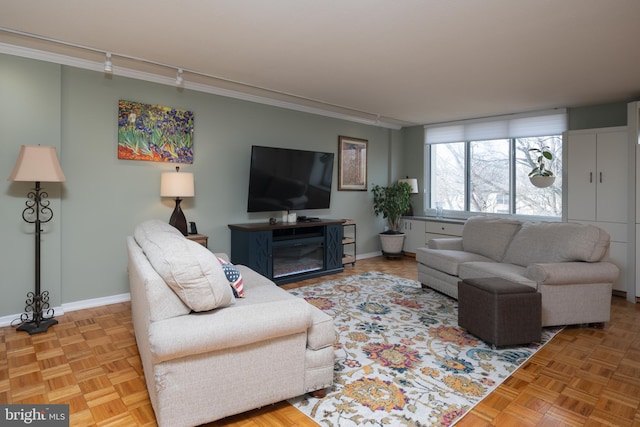 living room featuring light parquet flooring, rail lighting, and crown molding