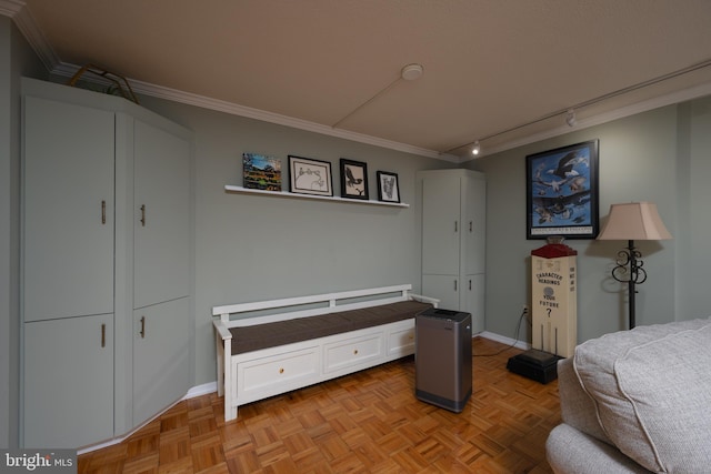 bedroom with light parquet flooring, ornamental molding, and track lighting