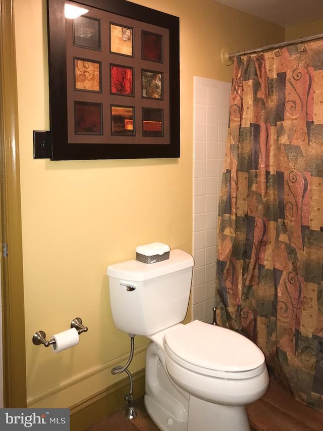 bathroom featuring toilet and a shower with shower curtain