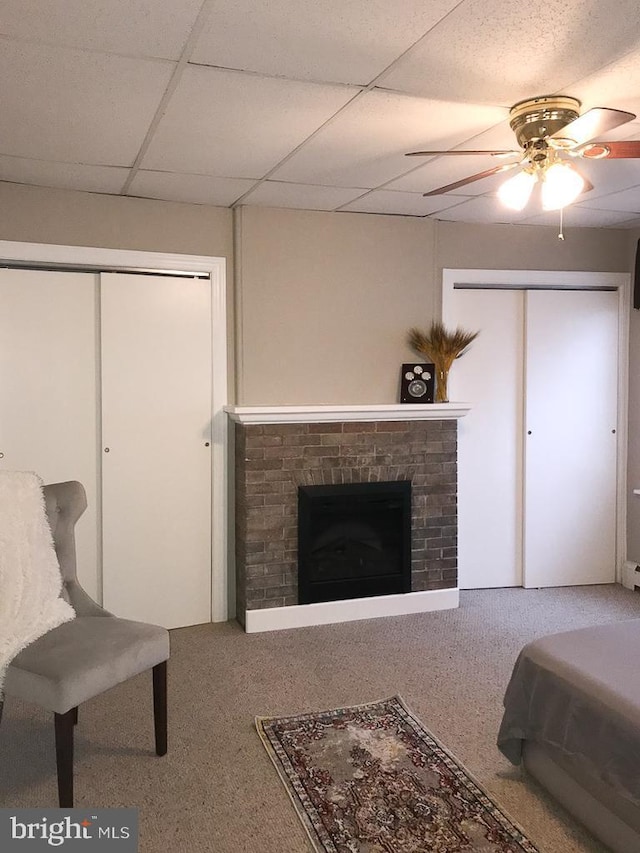 bedroom featuring a drop ceiling, carpet floors, and ceiling fan