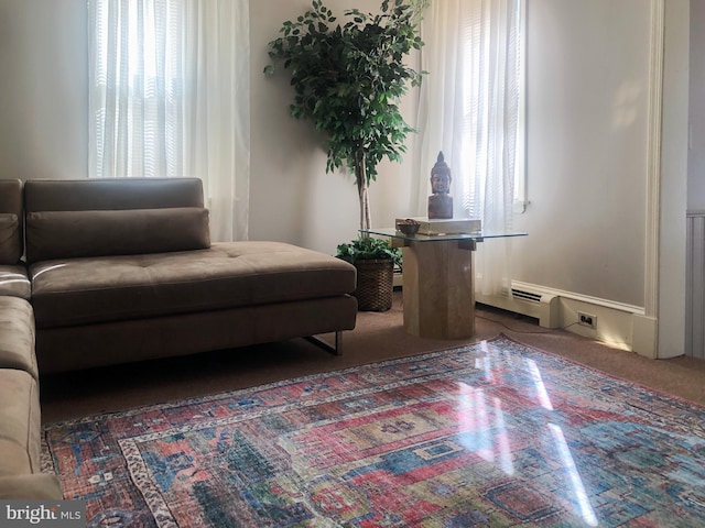 living area featuring plenty of natural light and dark carpet