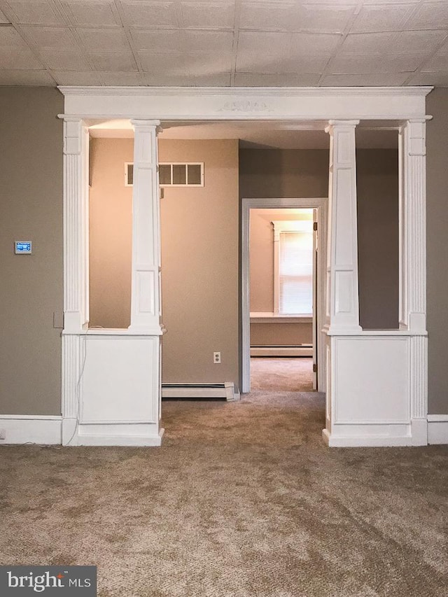 carpeted empty room featuring baseboard heating