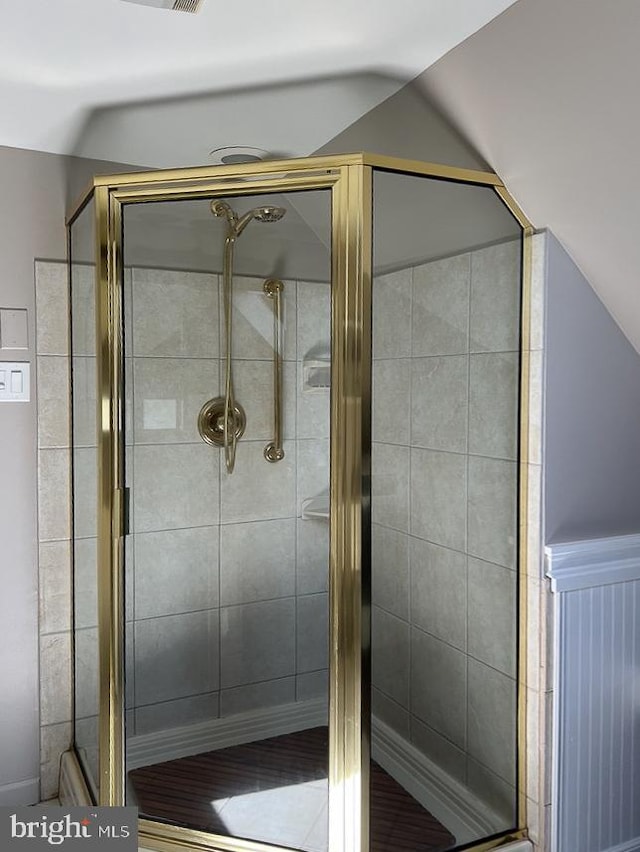 bathroom with vaulted ceiling and a shower with shower door