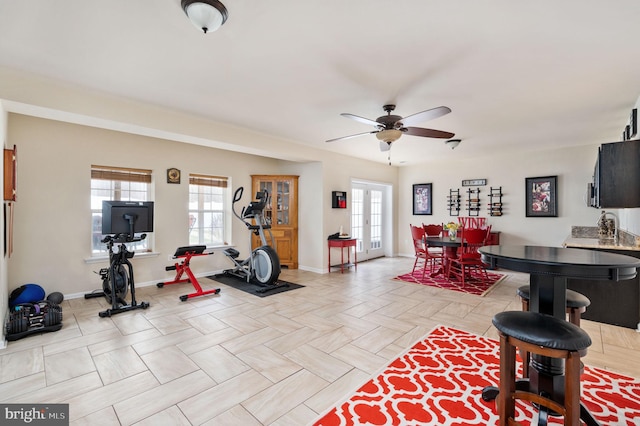 exercise room featuring baseboards, a wealth of natural light, and ceiling fan