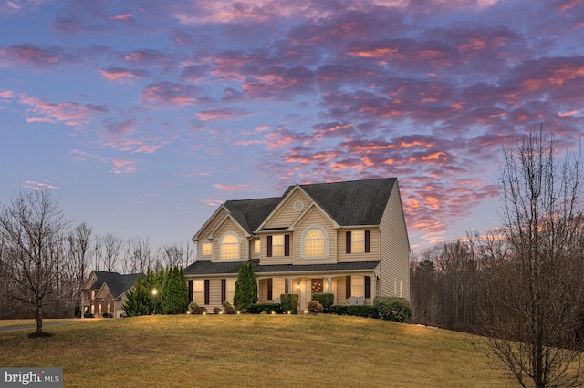 traditional-style house featuring a front lawn