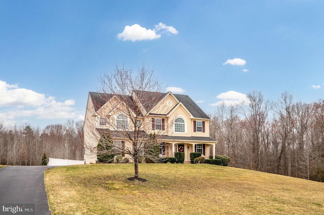 shingle-style home featuring a garage and a front yard