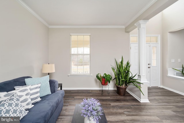 living room featuring decorative columns, baseboards, wood finished floors, and crown molding