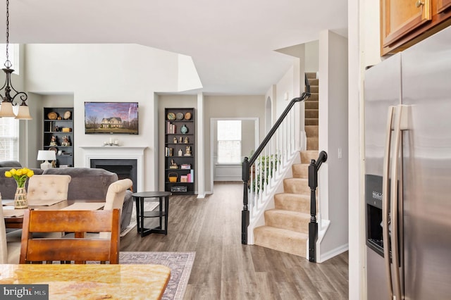 interior space with stairway, baseboards, wood finished floors, and a fireplace