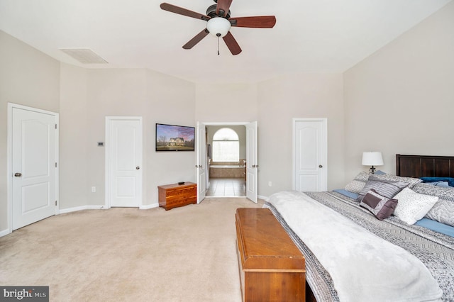 bedroom with baseboards, visible vents, high vaulted ceiling, light colored carpet, and connected bathroom