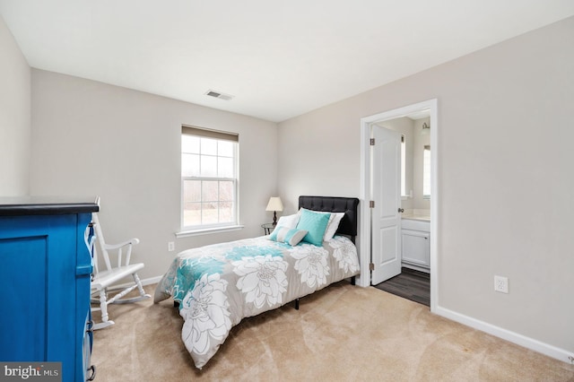 bedroom with visible vents, baseboards, ensuite bathroom, and carpet flooring