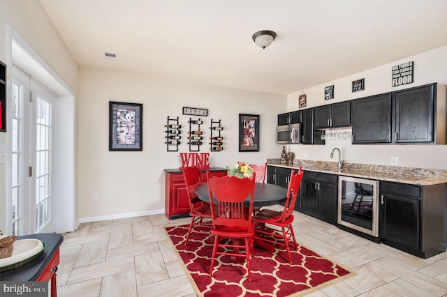 dining area featuring wet bar, wine cooler, visible vents, and baseboards