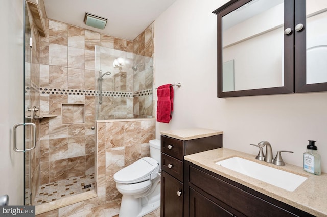 bathroom featuring a stall shower, toilet, and vanity