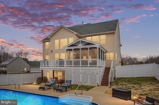 back of house featuring a patio, stairway, a fenced in pool, a fenced backyard, and a sunroom