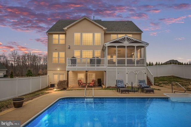 back of house featuring a patio, a fenced backyard, a sunroom, a fenced in pool, and stairs