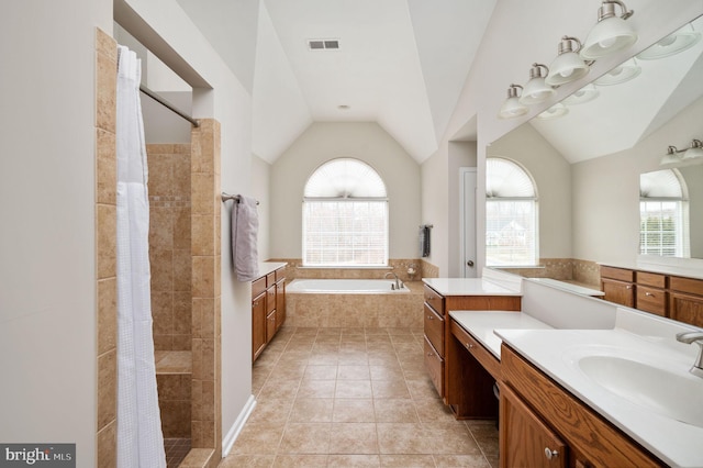 full bath featuring a wealth of natural light, visible vents, a tile shower, and vaulted ceiling