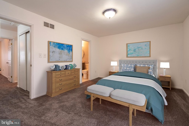 bedroom with ensuite bathroom and dark colored carpet