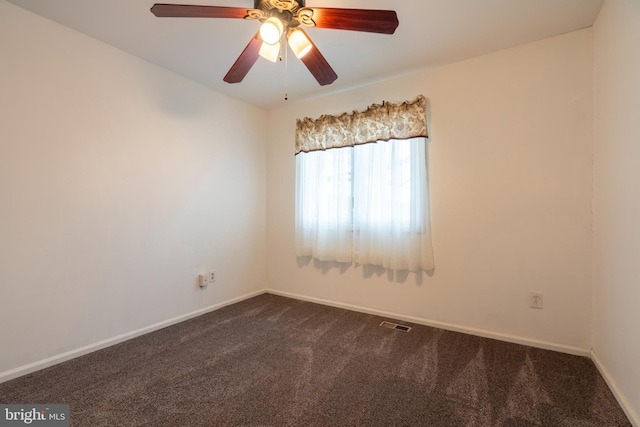 empty room featuring ceiling fan and dark colored carpet