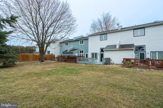 back of house with cooling unit, a yard, and a deck