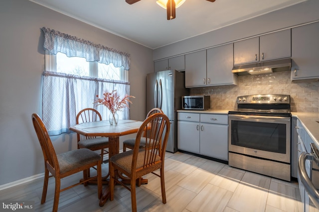 kitchen with tasteful backsplash, ceiling fan, stainless steel appliances, and gray cabinets