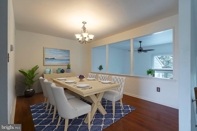 dining room featuring ceiling fan with notable chandelier and dark wood-type flooring