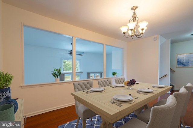 dining space with dark hardwood / wood-style floors and ceiling fan with notable chandelier