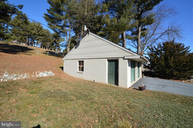 view of side of home with a yard and an outdoor structure