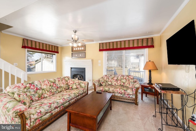 carpeted living room featuring ceiling fan, ornamental molding, and a brick fireplace