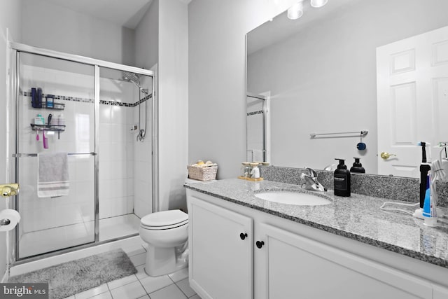 bathroom featuring walk in shower, vanity, toilet, and tile patterned flooring