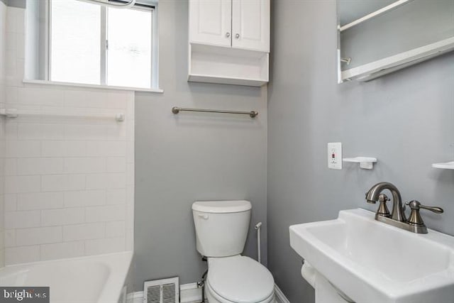 full bathroom with tiled shower / bath, toilet, and sink