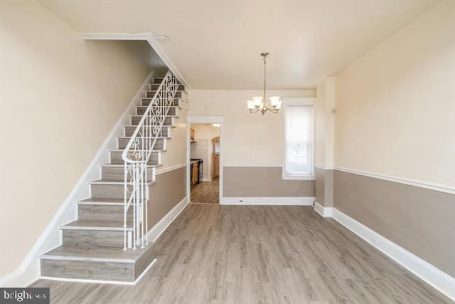 interior space featuring wood-type flooring and a notable chandelier