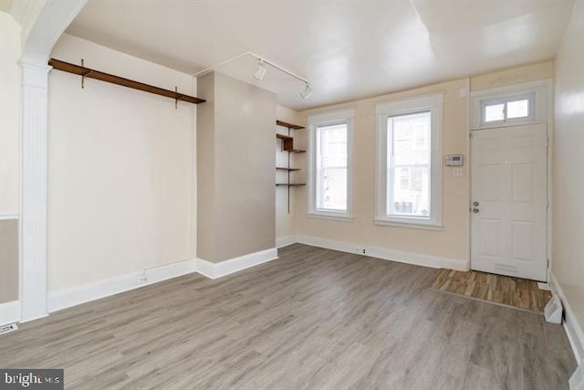 foyer entrance with track lighting and light hardwood / wood-style flooring