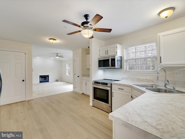 kitchen featuring white cabinetry, stainless steel appliances, sink, and plenty of natural light