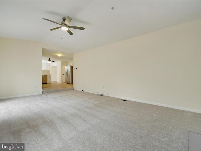 carpeted empty room with ceiling fan and vaulted ceiling