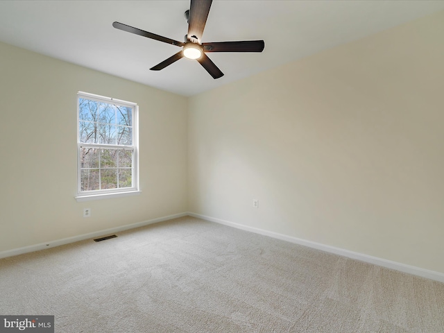 carpeted spare room featuring ceiling fan