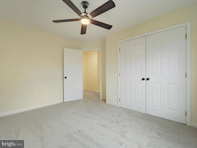 unfurnished bedroom featuring light colored carpet, a closet, and ceiling fan