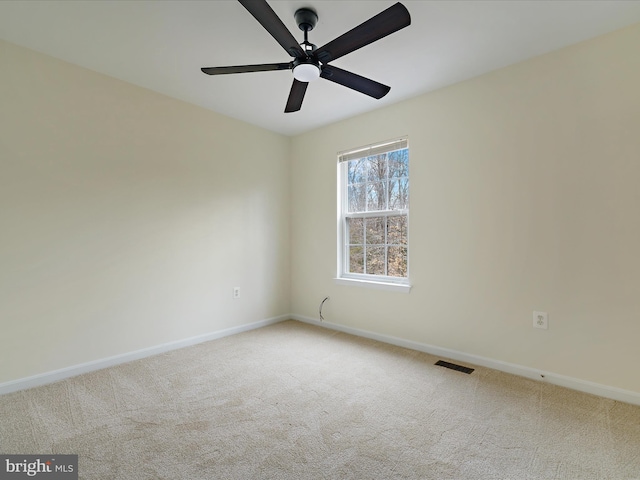 unfurnished room with ceiling fan and carpet