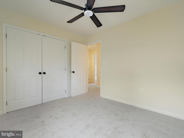 unfurnished bedroom featuring light colored carpet, a closet, and ceiling fan