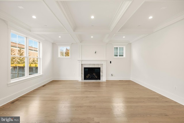 unfurnished living room with light wood-style flooring, coffered ceiling, beam ceiling, and baseboards