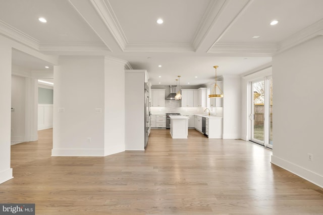 unfurnished living room with baseboards, light wood finished floors, recessed lighting, and crown molding