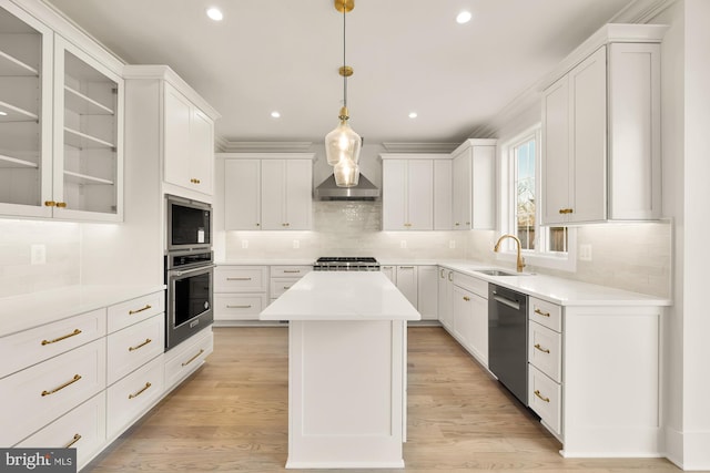 kitchen featuring stainless steel appliances, a kitchen island, a sink, white cabinets, and light countertops