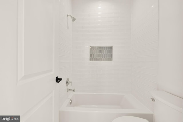 bathroom with washtub / shower combination and toilet