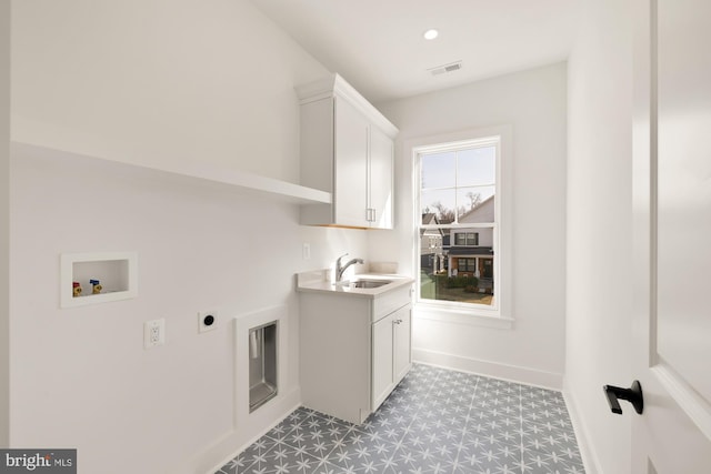 washroom featuring hookup for a washing machine, a sink, visible vents, cabinet space, and electric dryer hookup