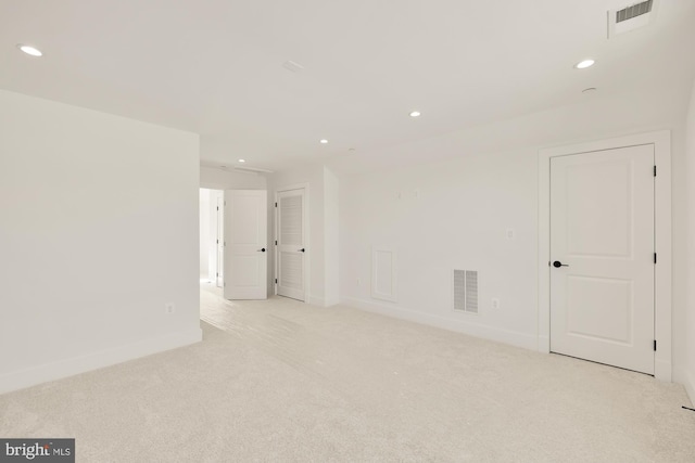 empty room with recessed lighting, visible vents, and light colored carpet