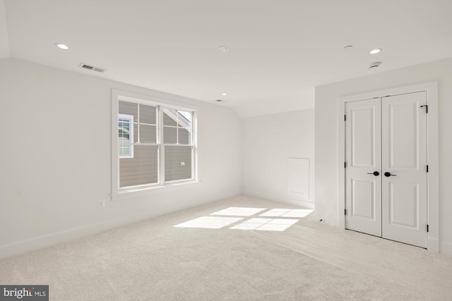 unfurnished room with lofted ceiling, visible vents, carpet flooring, and recessed lighting