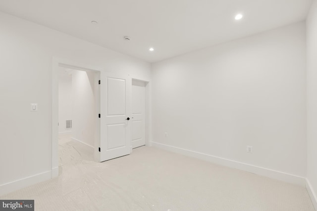 spare room featuring baseboards, visible vents, and recessed lighting