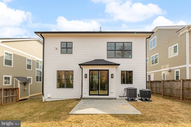 rear view of house with cooling unit, a fenced backyard, a patio, and a lawn