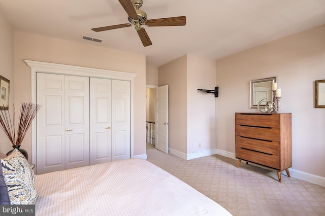 carpeted bedroom featuring ceiling fan and a closet