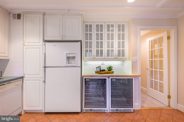 kitchen with white cabinets, tasteful backsplash, wine cooler, and white appliances