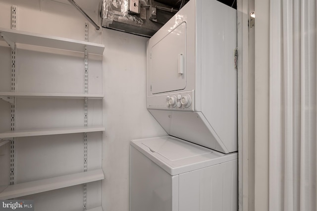 clothes washing area with stacked washer and clothes dryer